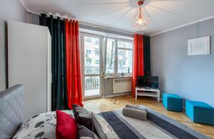 华沙ClickTheFlat Żurawia Street Apart Rooms的一间卧室配有红色窗帘、一张床和电视