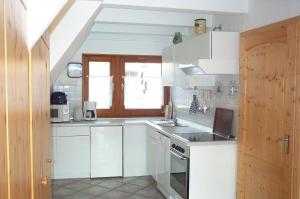 PresenPRHS08001-FeHaus-Diekkroon的白色的厨房设有水槽和炉灶。