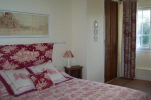 Chaumontel布维里尔庄园酒店的一间卧室配有一张带红白毯子的床