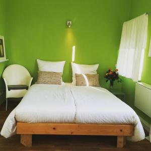 皮尔纳皮尔纳旅馆的绿色卧室配有一张带白色床单的大床