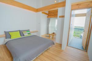 小琉球岛山邑家的一间卧室设有一张大床和一个大窗户