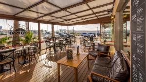萨格里什马雷塔海滩 - 精品住宿&早餐酒店的一间在甲板上配有桌椅的餐厅