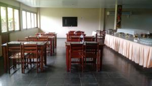 菲格雷多总统镇库卡法律酒店的一间带桌椅和电视的用餐室