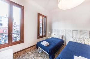 威尼斯Ca' d'Oro suite的一间卧室设有两张床和窗户。