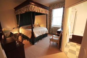 Hovingham卫斯利安酒店的一间卧室配有一张四柱床和天蓬