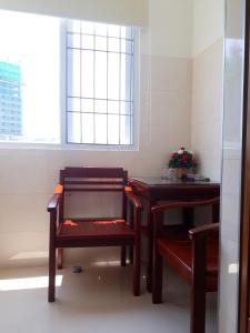 芽庄DUY HUY酒店公寓的一间设有两张桌子、一把椅子和一个窗户的房间
