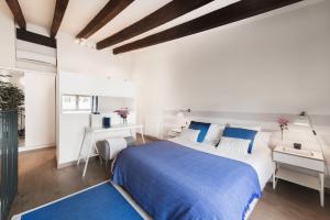 瓦伦西亚Victoria Site-Mercat Central的白色卧室配有蓝色的床和书桌