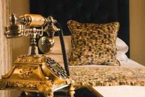 巴利米纳雷恩摩尔酒店的一张桌子上的金色电话,床边