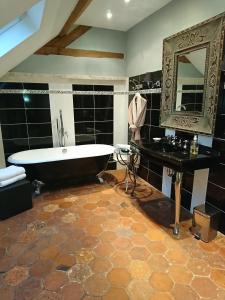 桑利斯科特迪瓦花园住宿加早餐酒店的带浴缸和镜子的大浴室