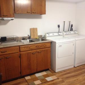 夏洛特顿赖特河小屋公寓的厨房配有水槽和洗衣机