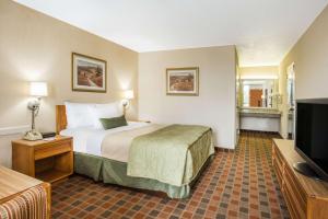 威斯维尔维瑟维尔华美达酒店的配有一张床和一台平面电视的酒店客房
