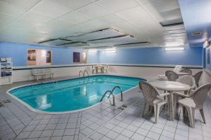 苏福尔斯华美达苏福尔斯酒店的一个带桌椅、桌子和桌子的房间的游泳池