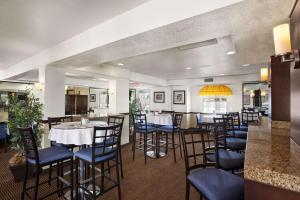 科斯塔梅萨梅萨海岸/纽波特海滩华美达旅馆及套房酒店的一间带桌椅的餐厅和一间酒吧