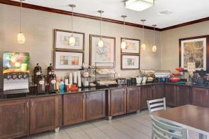 休斯顿华美达休斯敦洲际机场南酒店的厨房配有木制橱柜和带桌子的柜台。