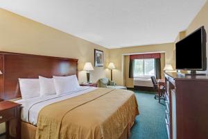 基特里基特里华美达酒店的配有一张床和一台平面电视的酒店客房