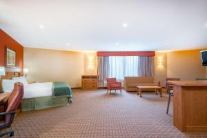 Urbandale得梅因华美达热带度假村/会议中心度假酒店的酒店客房设有床和客厅。