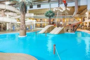 Urbandale得梅因华美达热带度假村/会议中心度假酒店的一个带滑梯和秋千的大型室内水上乐园