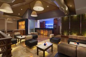 科钦Ramada Resort by Wyndham Kochi的一间带沙发和桌子的餐厅以及一个酒窖