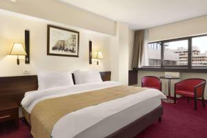 雅西雅西城市中心华美达酒店的一间设有大床和窗户的酒店客房