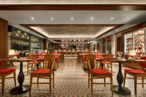 埃斯基谢希尔Ramada Encore Eskişehir的一间带桌椅的餐厅和一间酒吧