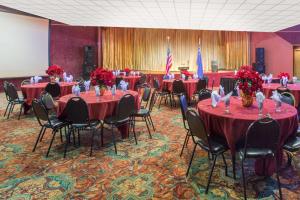 埃尔科埃尔科华美达酒店和赌场的一间会议室,配有红色的桌子、椅子和旗帜