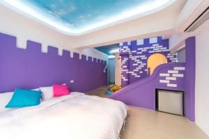 南湾墾丁南灣海遇親子 Meet you Nanwan的一间卧室配有一张床和紫色的墙壁