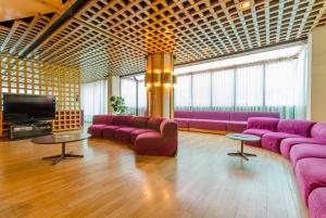 圣胡利娅-德洛里亚圣埃洛伊酒店的大型客房配有紫色沙发和电视。