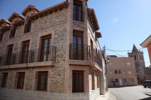 瓜达利斯-德拉谢拉Casa Rural La Fragua的一面设有一面阳台的砖砌建筑