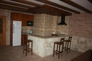 瓜达利斯-德拉谢拉Casa Rural La Fragua的厨房配有带椅子的柜台和冰箱。