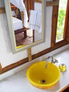 巴伊亚福尔莫萨Pousada Sabambugi的浴室里的一个黄色水槽,带有镜子