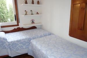 卡莱利亚德帕拉弗鲁赫尔Apartament Calella Park的一间卧室设有两张床、一个窗口和书架
