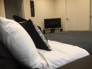 皮克顿Crow's Nest的一张带黑白枕头的床和一台电视