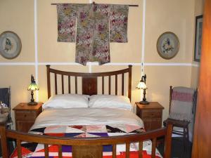 卢拉Lemon Tree Cottage的一间卧室配有一张床、两张桌子和两盏灯。