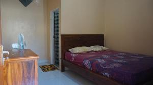 卡里蒙贾瓦Arriani Homestay的一间卧室配有一张床和一个木制梳妆台