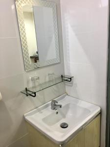 拉布安甘加拉之家度假屋的白色的浴室设有水槽和镜子