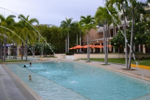 纳苏格布鹦鹉嘴公寓的一座大型游泳池,在一座建筑前种有棕榈树