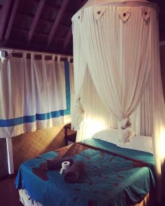 Afaahiti普纳提村庄酒店的一间卧室配有一张带天蓬和窗帘的床