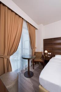 阿格里尼翁阿格里尼翁帝国酒店的一间卧室配有一张床、一张桌子和一个窗户。