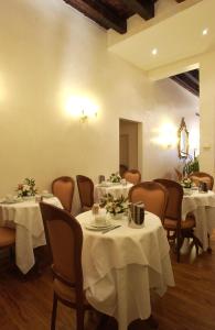 威尼斯坎达运河酒店的用餐室配有桌椅和白色桌布