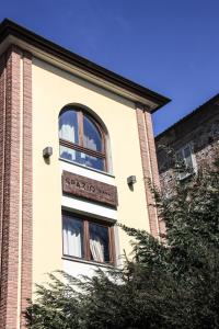 伊夫雷亚斯帕齐奥[比安科]酒店的建筑上有一个窗口,上面有标志