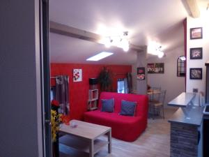 巴勒迪克Les Ponts de l'Ornain的客厅配有红色的沙发和桌子