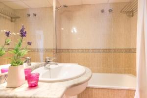 圣苏珊娜Europa Square Apartment的浴室配有盥洗盆和浴缸。