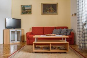 波斯托伊纳Apartment & rooms Grmek的客厅配有红色沙发和电视