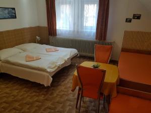 塔特兰斯卡科特利纳Vila Zdenka的酒店客房带一张床、一张桌子和椅子