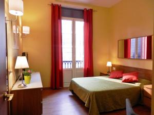 巴塞罗那Barcelona Central Garden Hostal的一间卧室配有床和红色窗帘的窗户