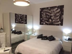 陶尔米纳伊索克旅馆的卧室配有带黑色枕头的白色床
