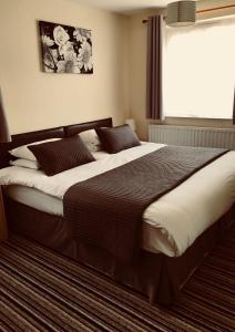 剑桥桤木旅馆的卧室内的一张大床,设有窗户