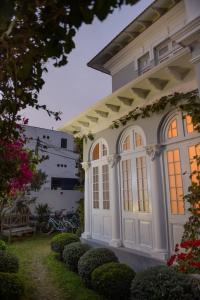 利马Villa Barranco by Ananay Hotels的白色的房子,设有窗户和灌木丛