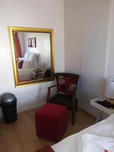 东伦敦Lighthouse Accommodation的一间卧室配有镜子、椅子和一张床