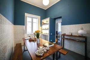 巴勒莫Family Affair Palermo的一间拥有蓝色墙壁和木桌的用餐室